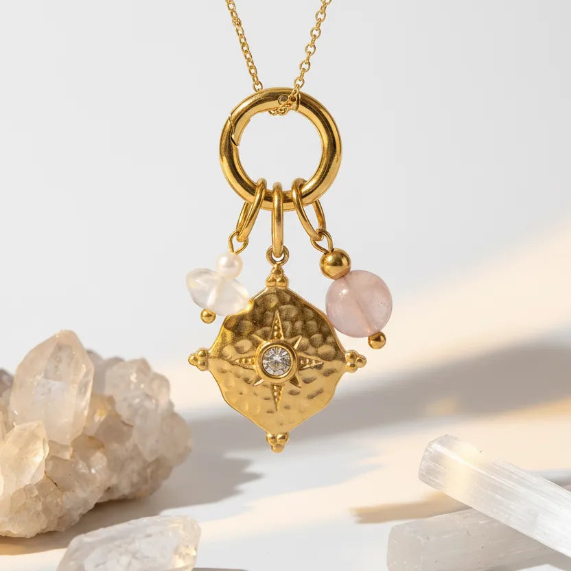 Gold keychain with gemstones on a light background