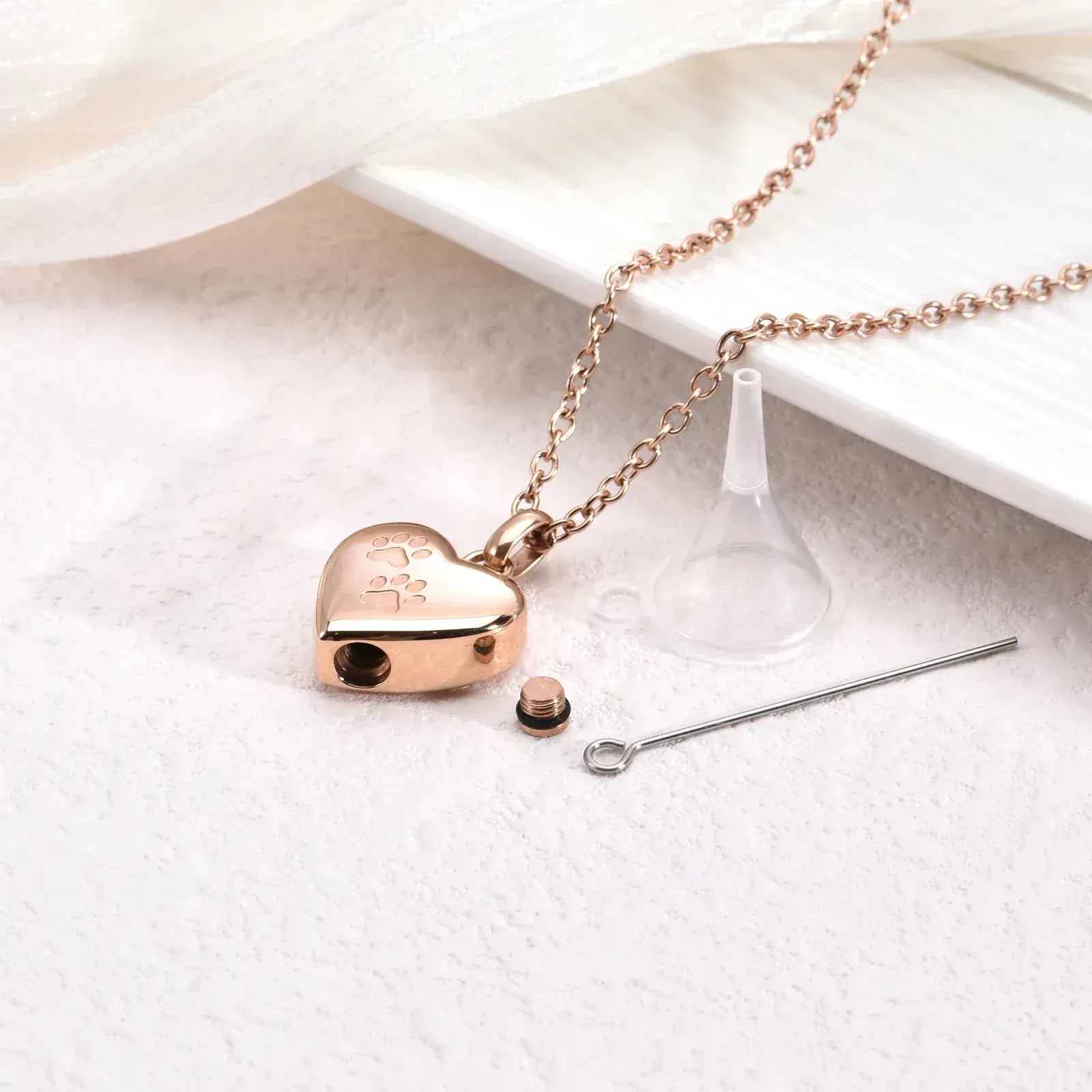 Rose gold heart-shaped pendant with chain on a white surface