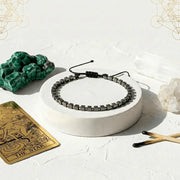 Necklace on a white pedestal with crystals and a tarot card on a light background