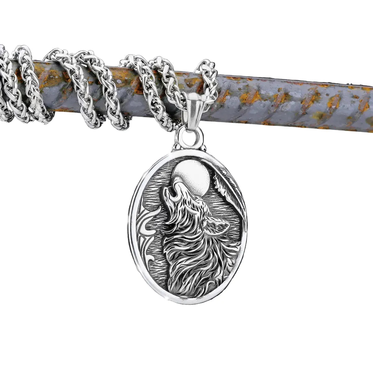 Silver pendant with wolf design on a chain against a background