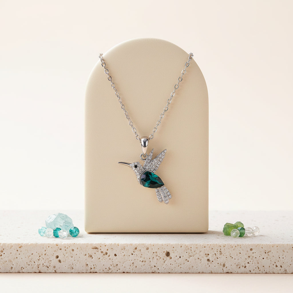 Woman wearing a teal hummingbird pendant necklace in sterling silver — spirit animal jewelry for lightness