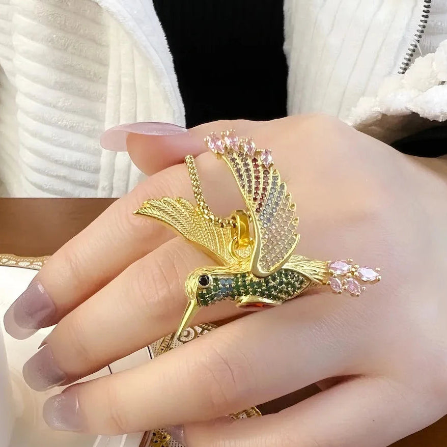 Gold hummingbird-shaped ring on a hand  