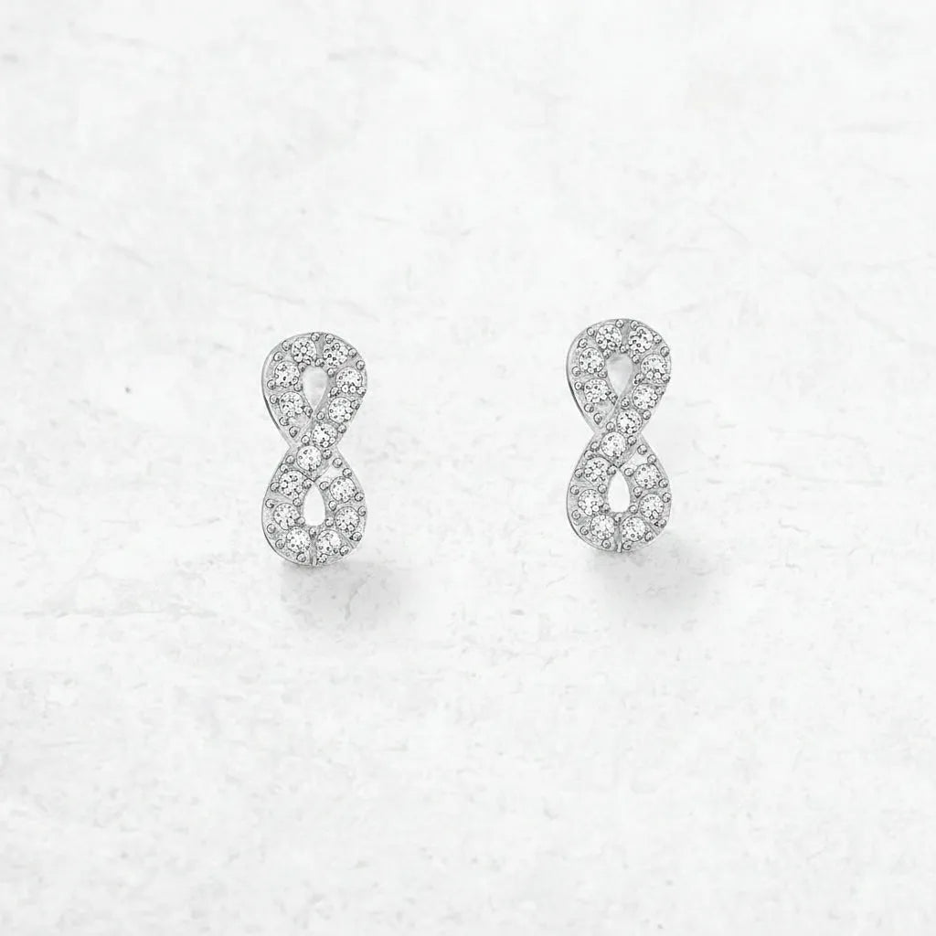 Silver infinity symbol earrings on a light gray background 