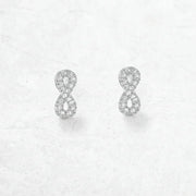 Silver infinity symbol earrings on a light gray background 