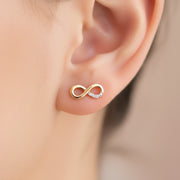 gold infinity symbol stud earring worn on the ear — spiritual symbol jewelry for eternal connection