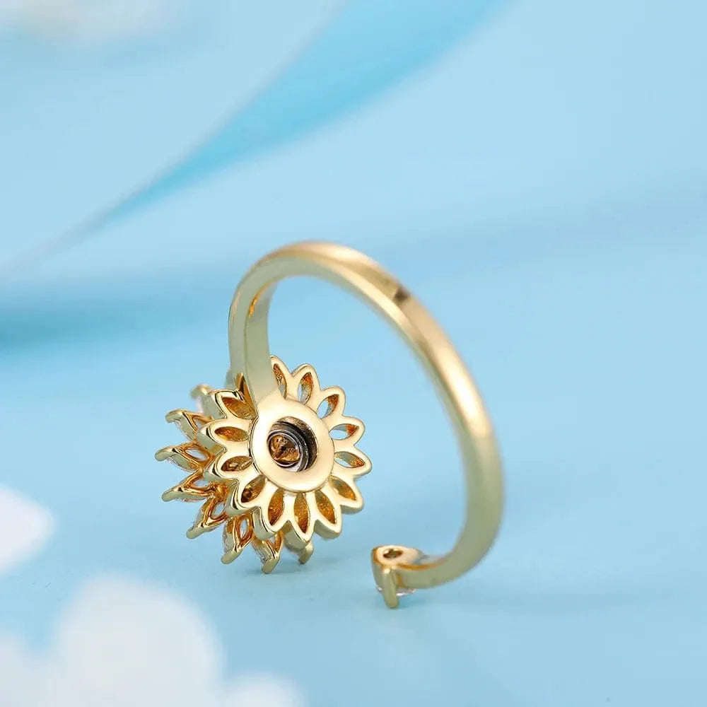 Gold sun-shaped ring on a light blue background