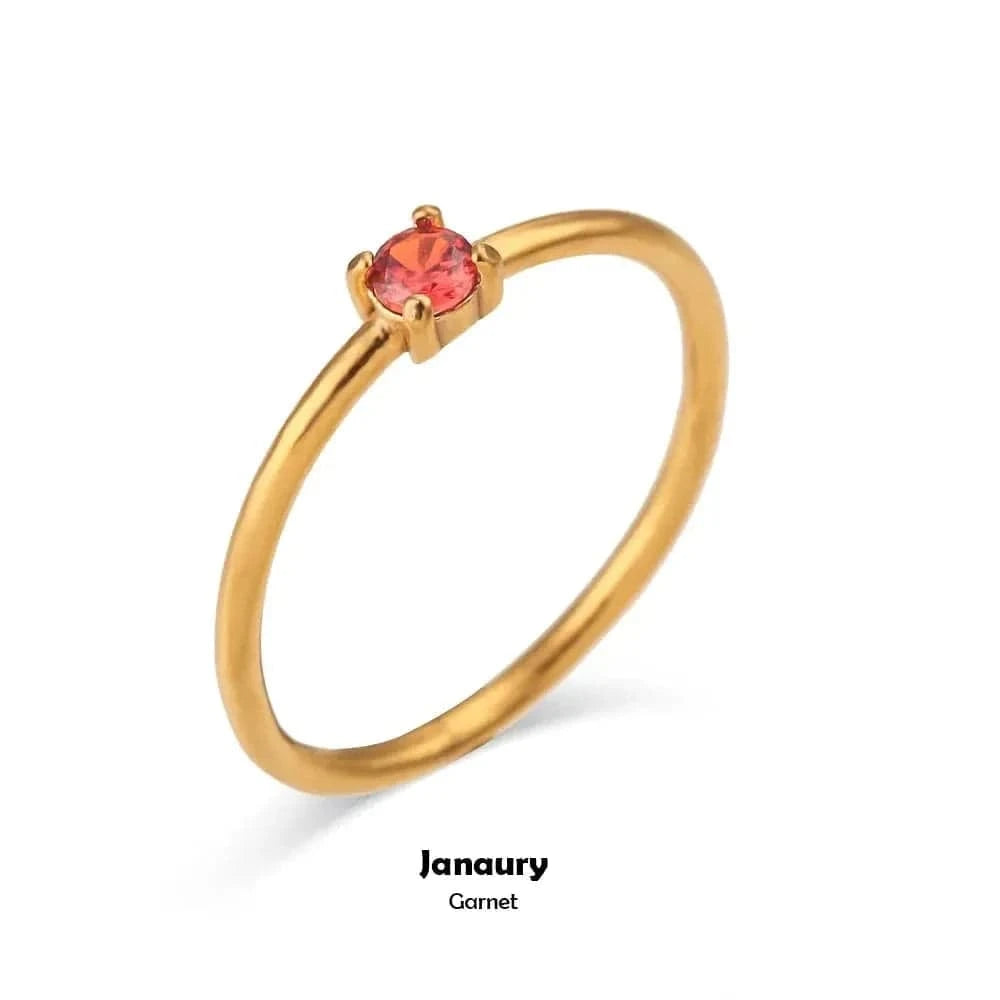 Gold ring with a red gemstone on a white background, labeled 'January Garnet'.