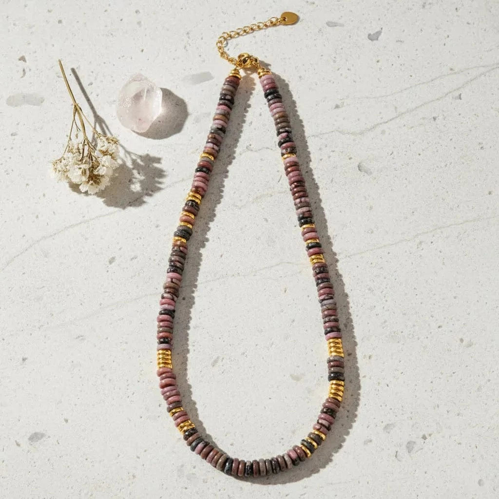 Necklace with multicolored beads and gold accents on a white background