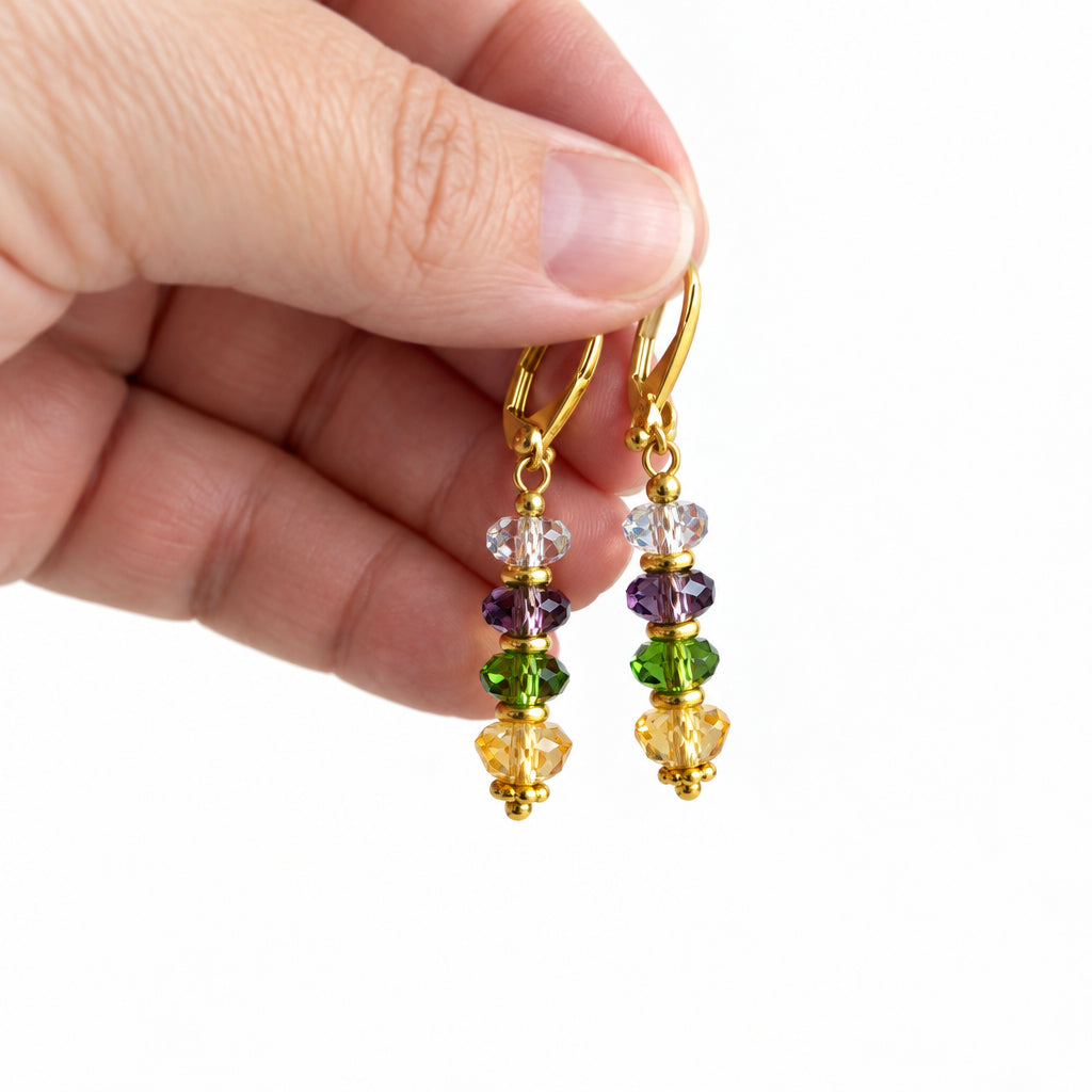 Hand holding jewel tone faceted glass drop earrings to show their small size