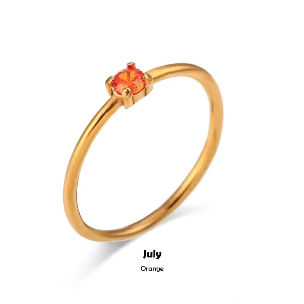 Gold ring with an orange gemstone on a white background