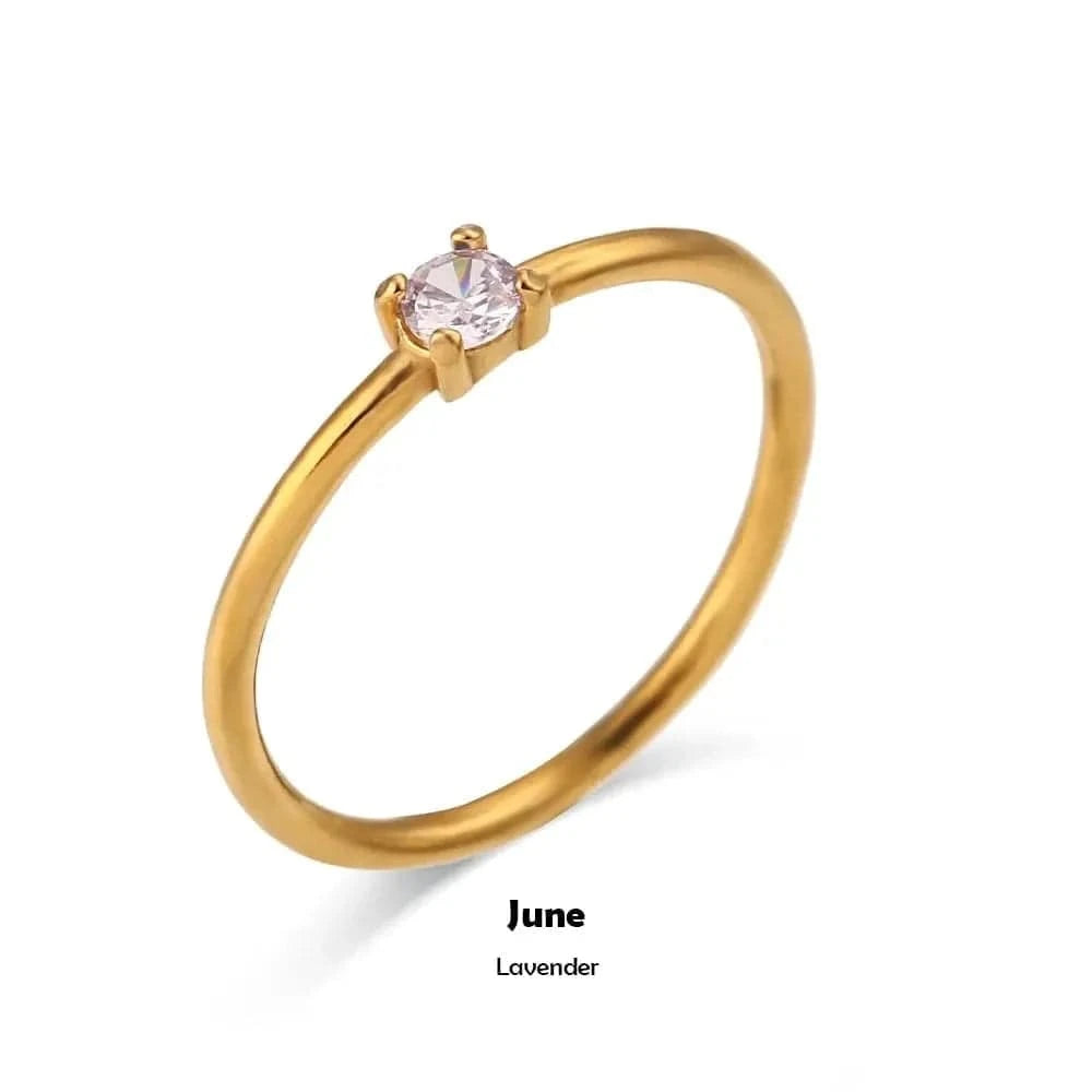 Gold ring with a pink gemstone on a white background