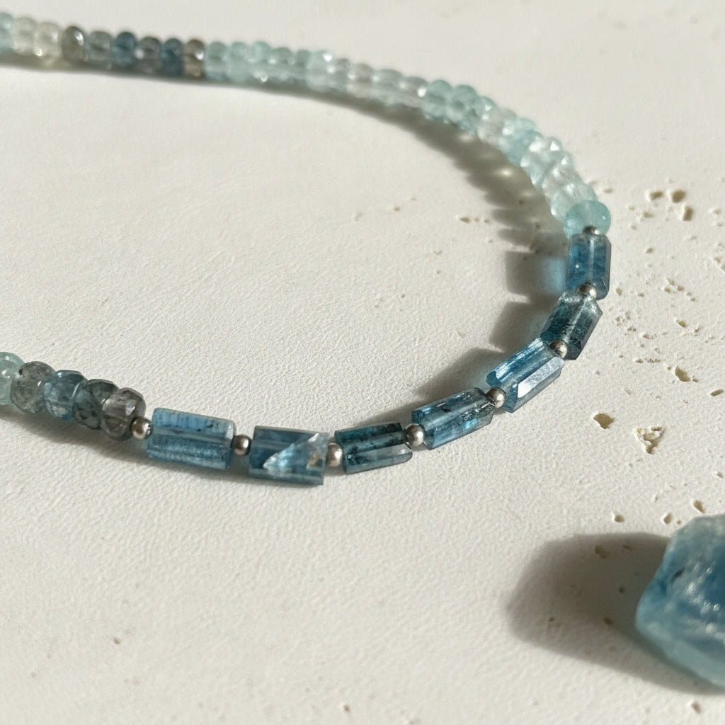 Close-up of faceted natural kyanite rondelle beads shading deep teal to light aqua
