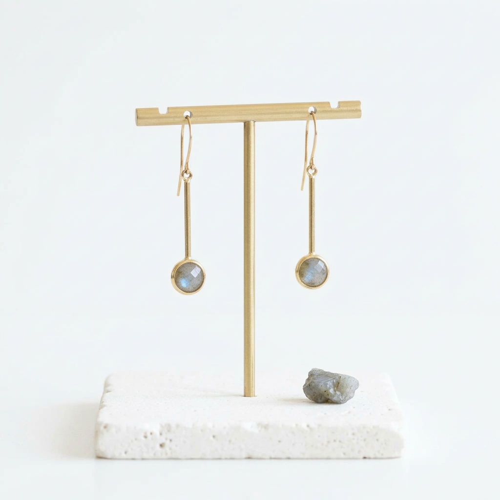 Long gold bar earrings with round labradorite drops, hanging on a gold stand