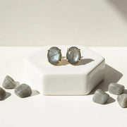 Lapis lazuli earrings on a white surface with lapis stones.