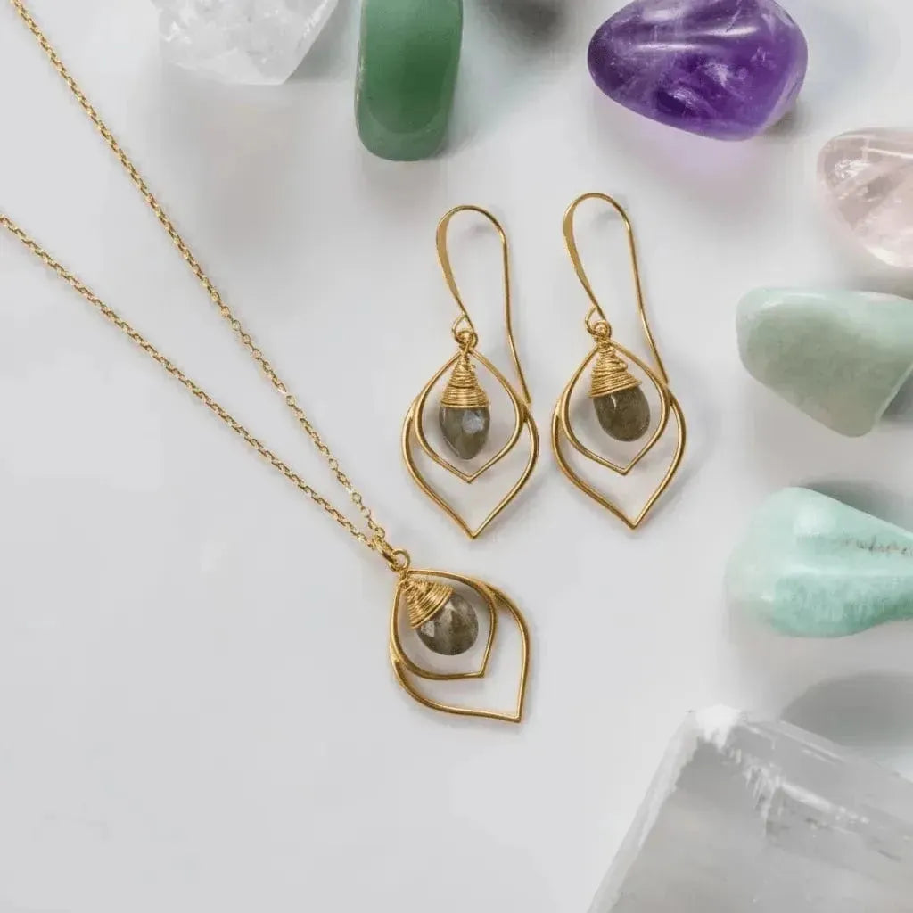 Silver jewelry set with pendant and earrings on a light surface with crystals.