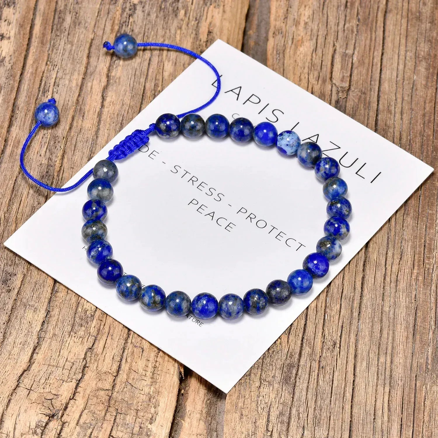 Blue beaded bracelet on a card with text on a wooden surface