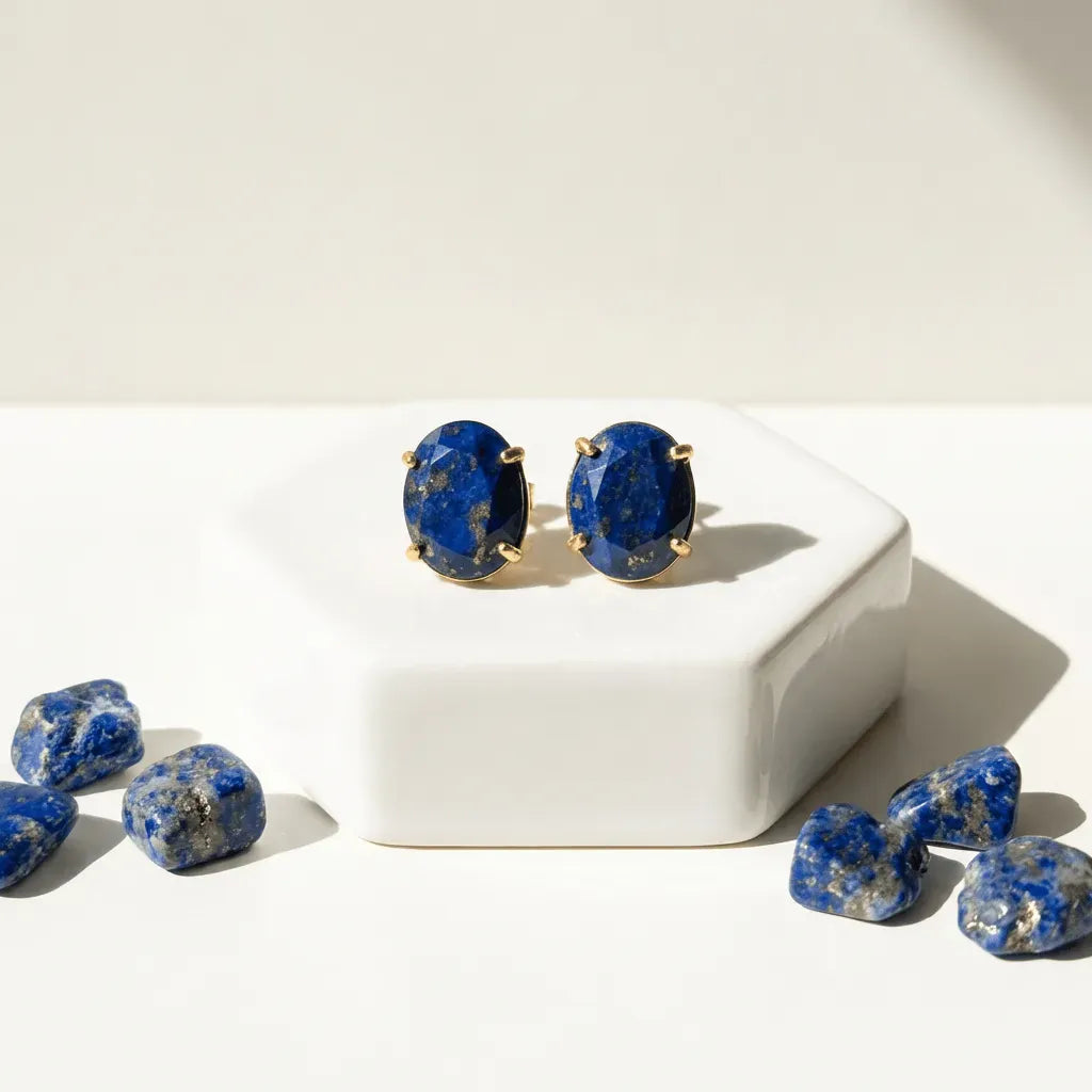 Lapis lazuli earrings on a white surface with loose stones.