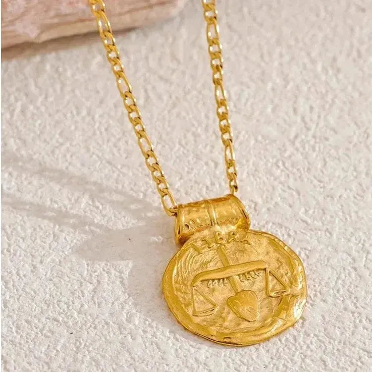 Gold necklace with a round pendant on a textured surface