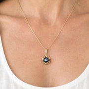 Woman wearing the gold floating evil eye necklace at the collarbone, shown for size