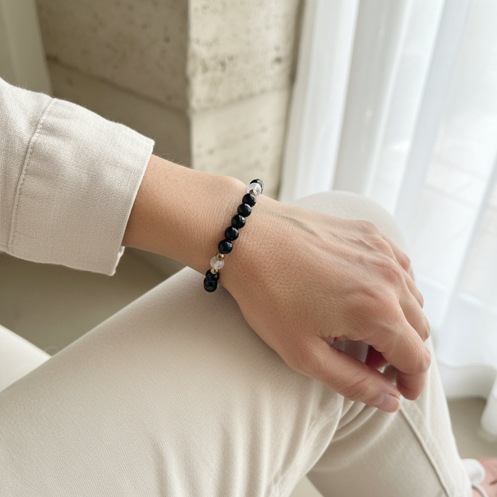 Woman wearing onyx and moonstone stretch bracelet — faceted crystal jewelry for boundaries