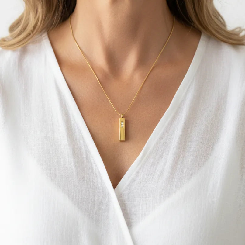 Woman wearing a gold crystal encrusted vial necklace, keepsake jewelry