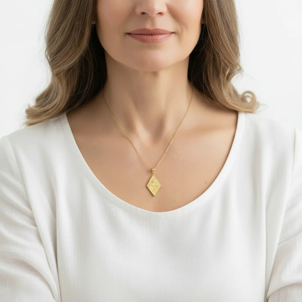 Woman wearing a rhombus sun, moon and star necklace in gold, celestial jewelry