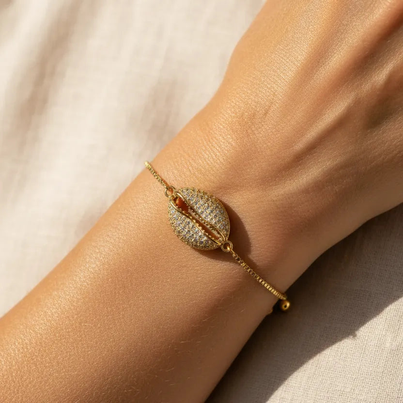 Woman wearing a gold cowrie shell beach bracelet