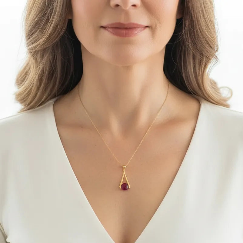 Woman wearing a triangle ruby drop necklace, July birthstone jewelry