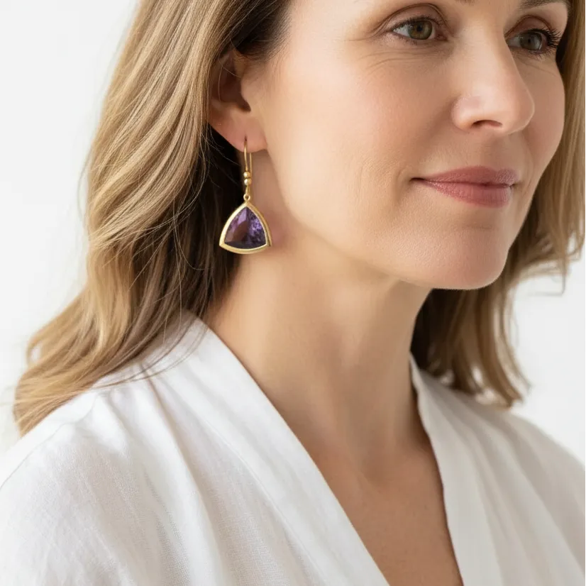 Woman wearing amethyst Aria drop earrings in gold, February birthstone jewelry