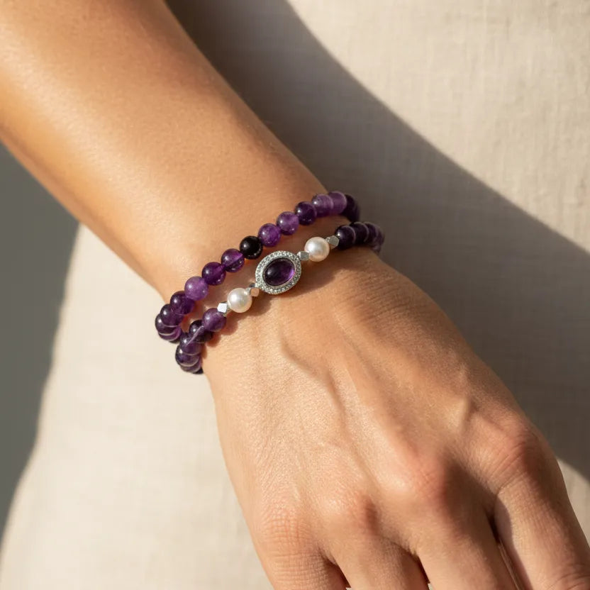 Woman wearing an amethyst and pearl stretch bracelet set, February birthstone jewelry