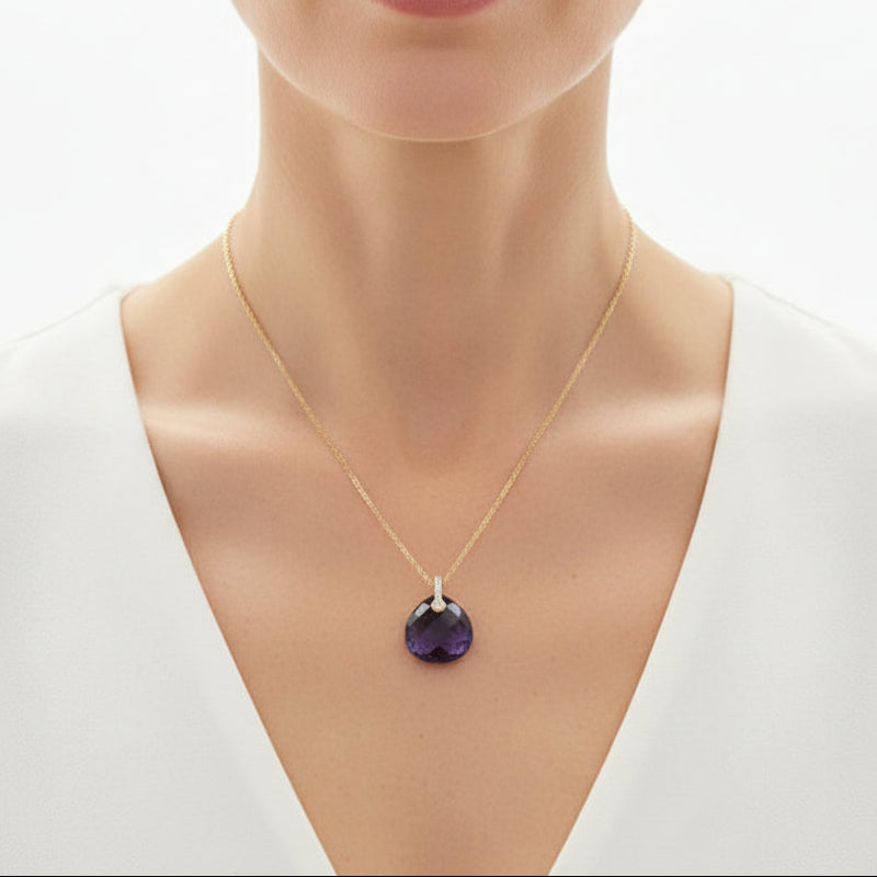 Woman wearing a gold amethyst pear drop pendant necklace — February birthstone jewelry