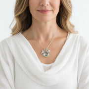 Woman wearing an aqua blue drop necklace with starfish and shell charms in silver, ocean charm jewelry