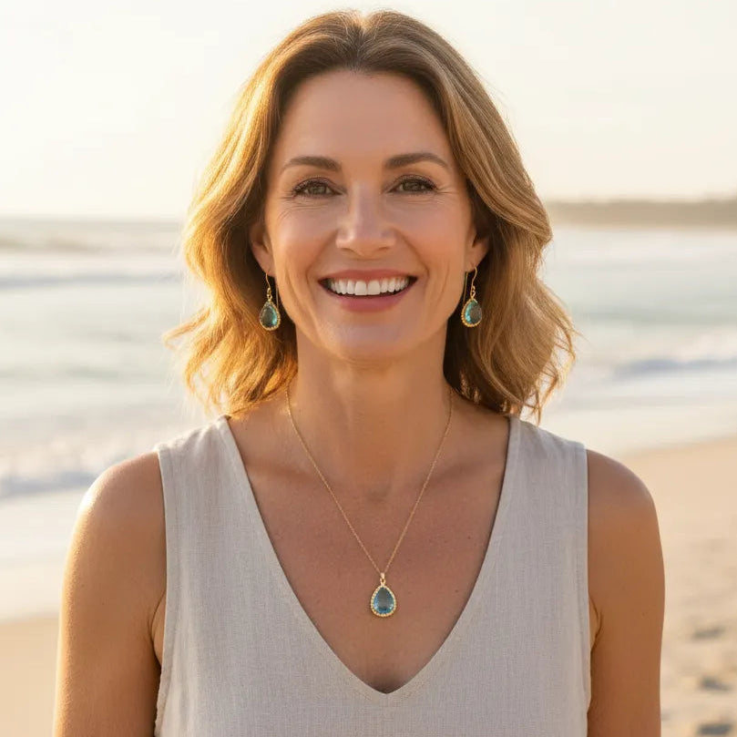 Woman on beach wearing aqua blue exquisite necklace and earrings, March birthstone jewelry