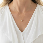 Woman wearing a horseshoe pendant necklace, good luck symbol jewelry