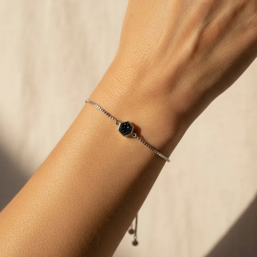 Woman wearing a black hexagon druzy bracelet with silver beads