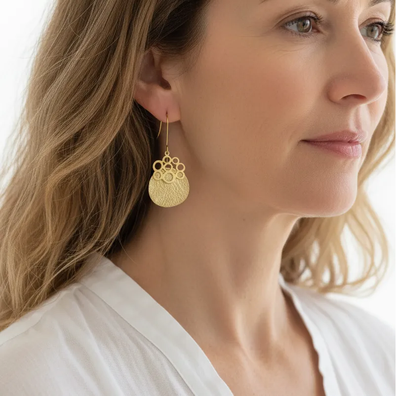 Woman wearing gold bubble drop statement earrings