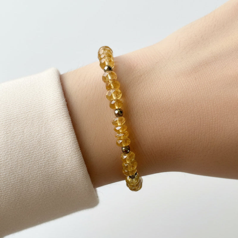 Woman wearing a faceted citrine and pyrite beaded bracelet, November birthstone jewelry