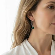 Woman wearing emerald green Cleo triangle drop earrings, May birthstone jewelry