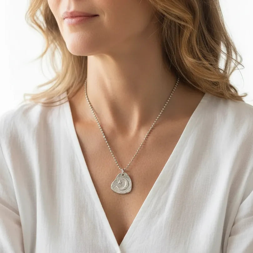 Woman wearing a silver crescent moon and star charm necklace, celestial jewelry