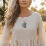 Woman in a field wearing a silver wolf and crescent moon necklace — spirit animal jewelry