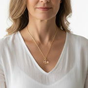 Woman wearing a clear quartz crown chakra necklace in gold
