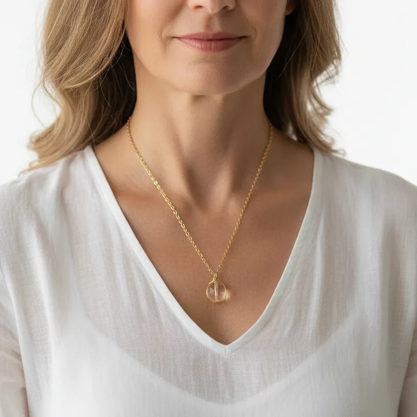 Woman wearing a clear quartz crown chakra necklace in gold