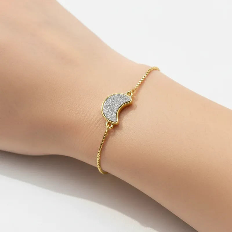 Woman wearing a grey druzy gemstone crescent moon bracelet, celestial jewelry