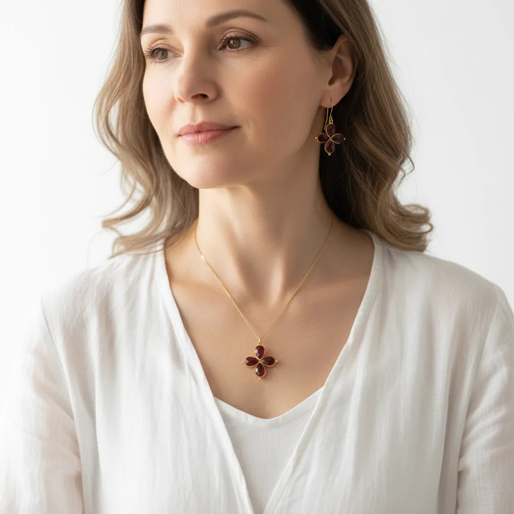 Woman wearing a garnet necklace with matching earrings, January birthstone jewelry
