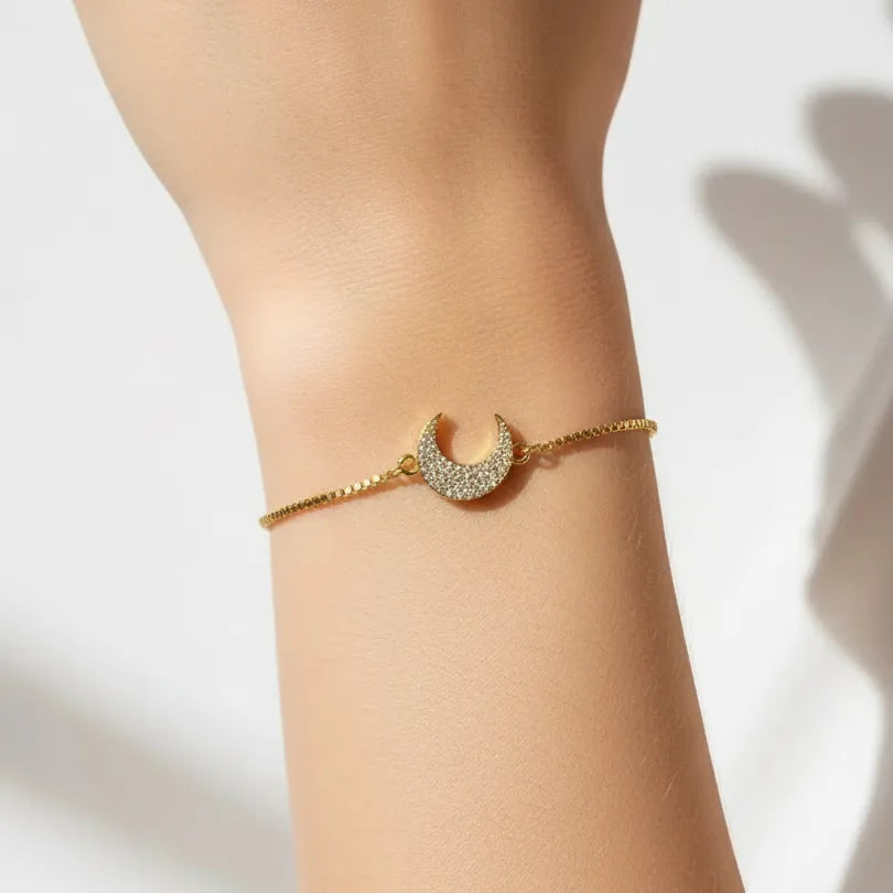Woman wearing a gold crescent moon bracelet, celestial jewelry