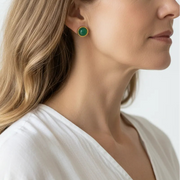 Woman wearing green agate stud earrings in gold