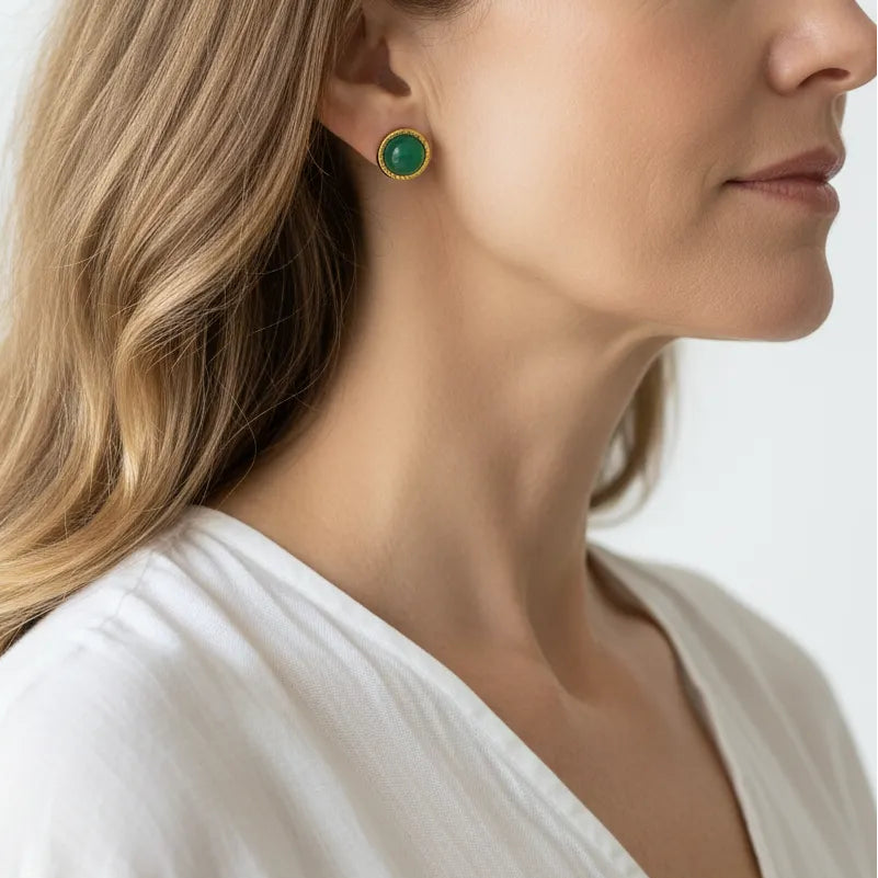 Woman wearing green agate stud earrings in gold