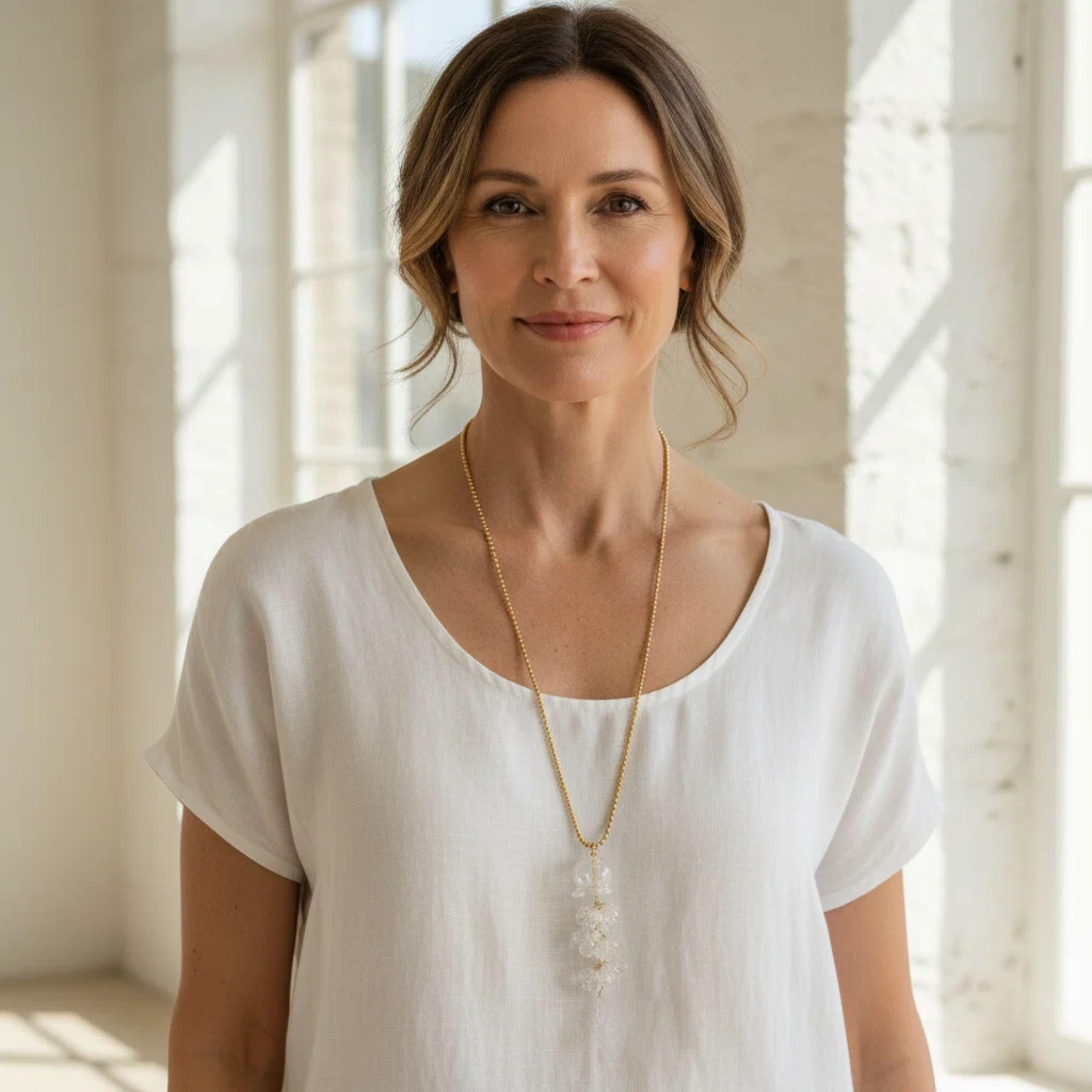 Woman wearing a glass jellyfish pendant necklace on a gold chain