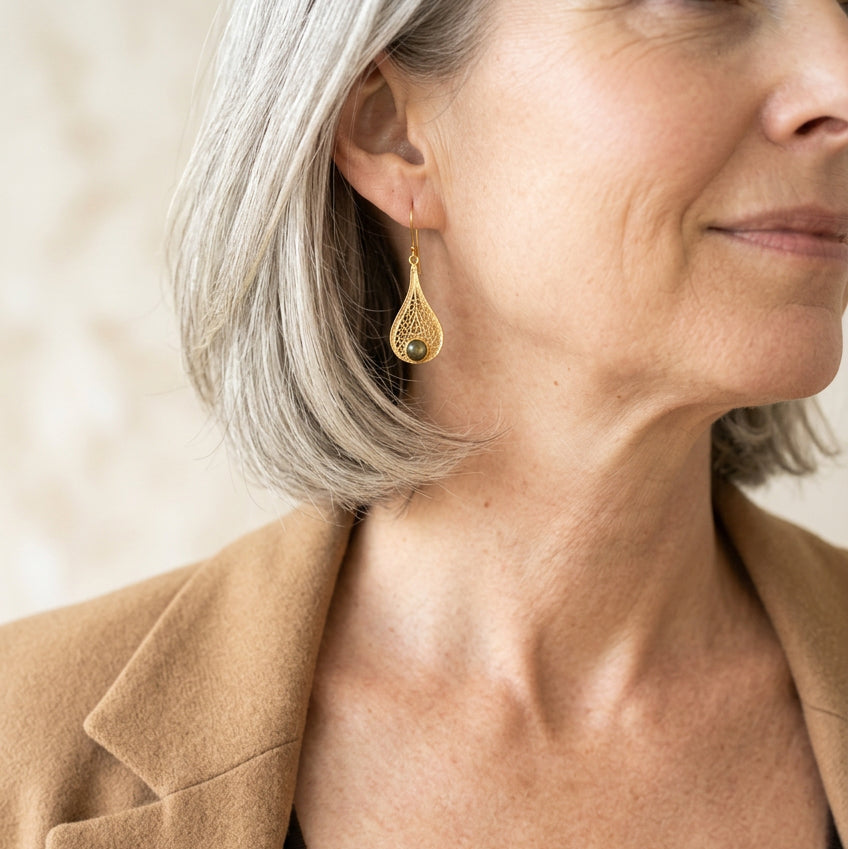 Woman wearing gold filigree teardrop labradorite earrings