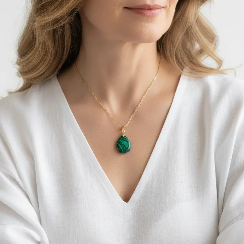 Woman wearing a gold malachite necklace, heart chakra jewelry